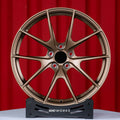 Audi RS3 8Y 18 inch custom forged wheels | Apex VS-5RS style Satin Bronze finish, straight front view on red backdrop showcasing track-inspired split-spoke design