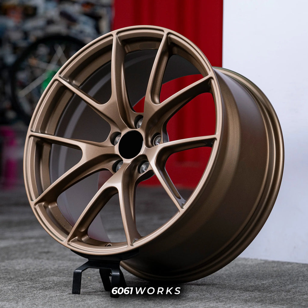 BMW M3 G80 20 inch custom forged wheels | Apex VS-5RS style Satin Bronze finish, three-quarter view on display stand highlighting lightweight motorsport split 5-spoke geometry