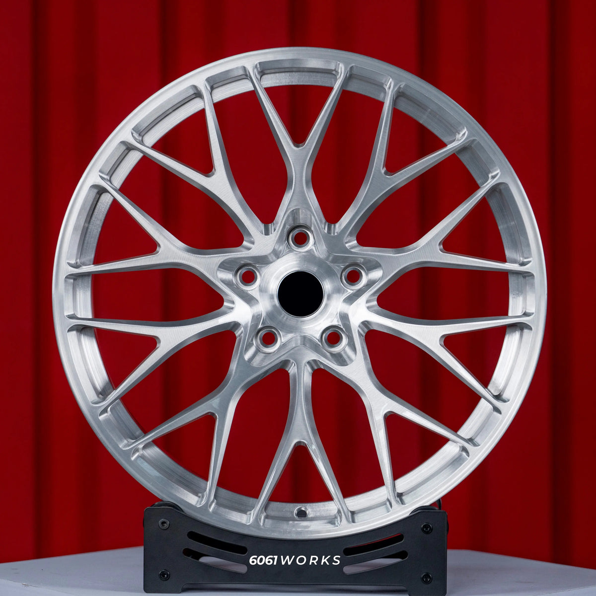 BMW M5 G90 22 inch custom forged wheels | 520M style Brushed Silver finish, straight front view on display stand showcasing complex performance split-spoke pattern