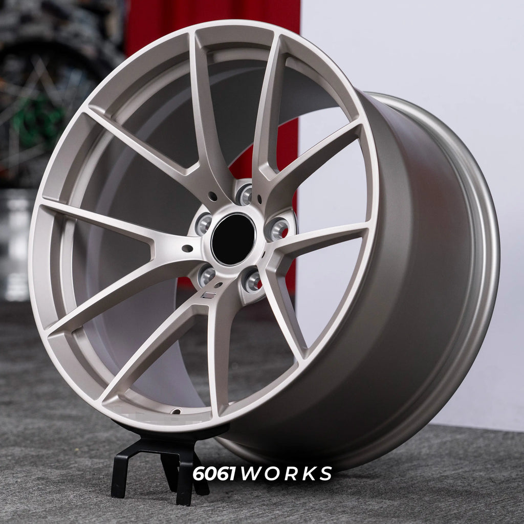 BMW M5 G90 22 inch custom forged wheels | OEM BMW 763M style Satin Gold finish, three-quarter view on display stand showing lightweight performance Y-spoke geometry