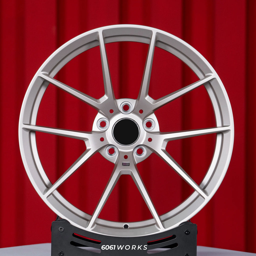 BMW M5 G90 22 inch custom forged wheels | OEM BMW 763M style Satin Gold finish, straight front view on red backdrop displaying Motorsport-inspired 5 Y-spoke pattern