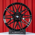 BMW X5 M F95 22 inch custom forged wheels | OEM BMW 818M style Gloss Black with Machined Face Dark Coating, straight front view on display stand showcasing iconic dual-tone M wheel design
