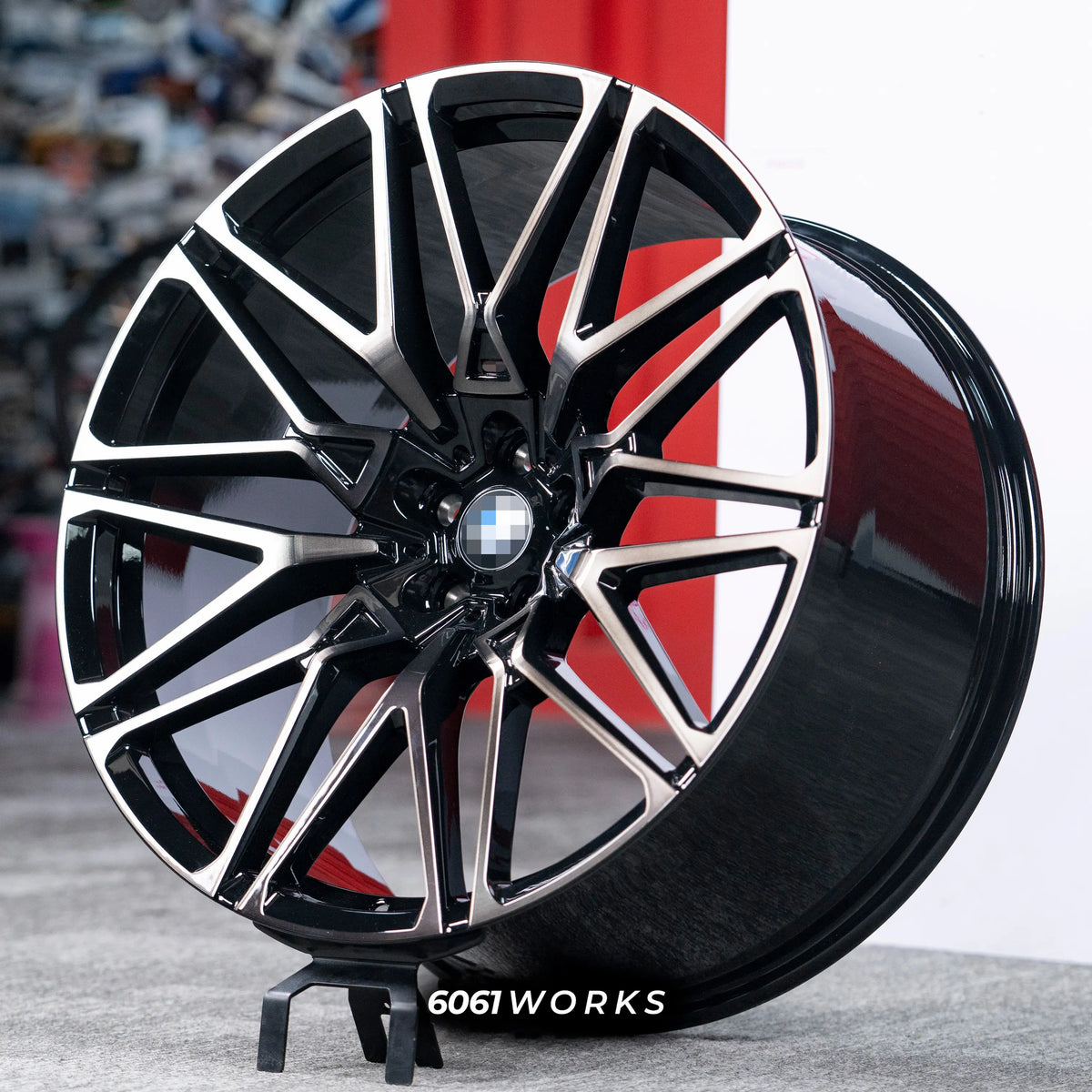 BMW X6 G06 22 inch custom forged wheels | OEM BMW 818M style Gloss Black with Machined Face Dark Coating, three-quarter view on display stand highlighting aggressive split-spoke profile