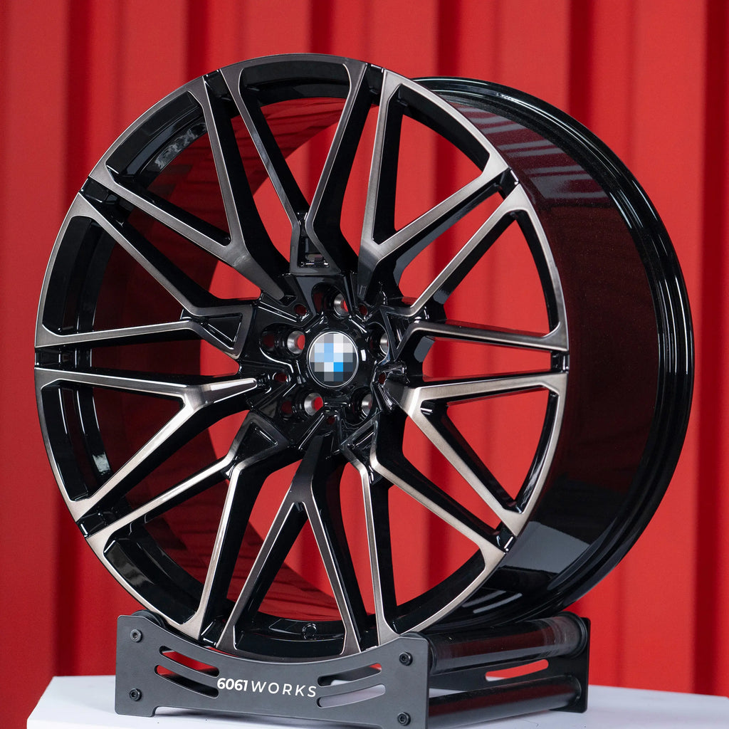 BMW X6 G06 22 inch custom forged wheels | OEM BMW 818M style Gloss Black with Machined Face Dark Coating, dynamic angled view on display stand showing dark tint clear coat over machined face