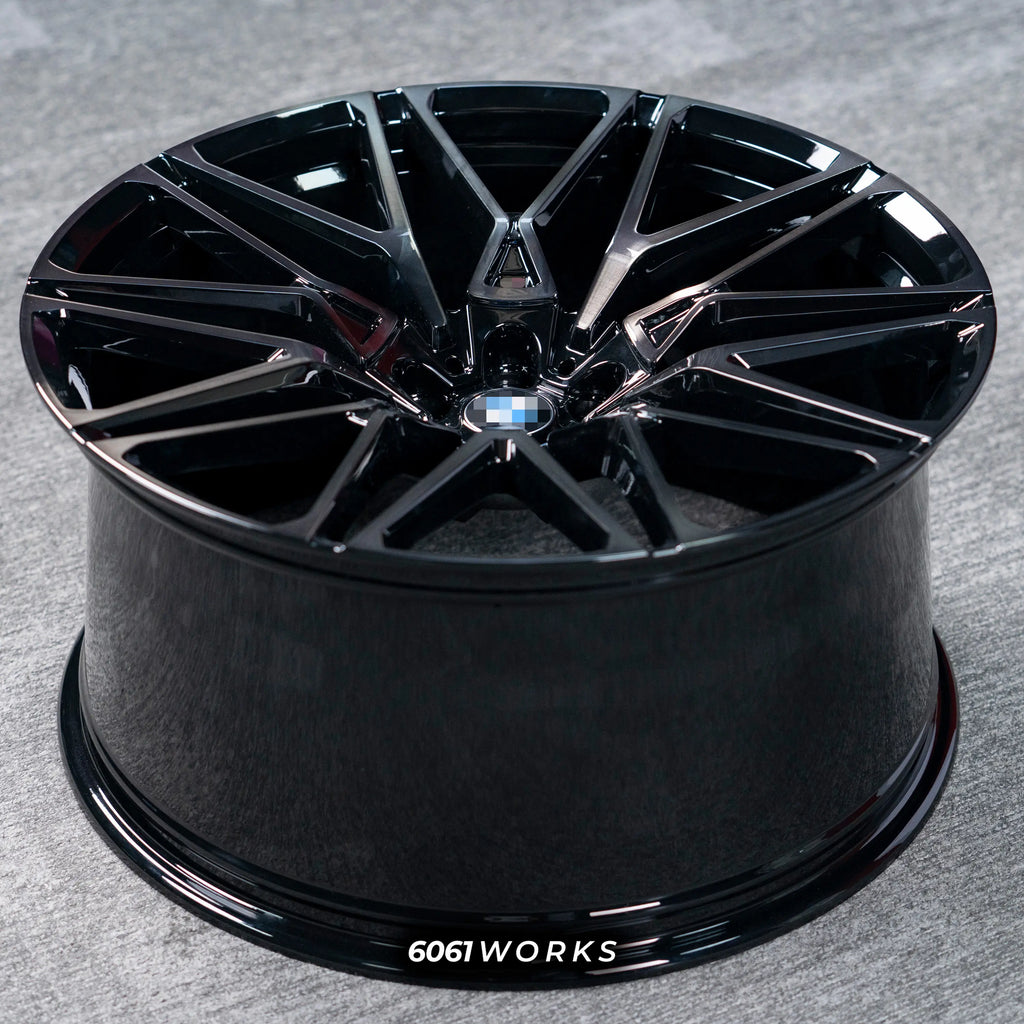 BMW X6M F96 LCI 21 22 inch custom forged wheels | OEM BMW 818M style Gloss Black with Machined Face Dark Coating, top-down angled profile view showing full wheel width and inner barrel
