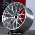Porsche 911 992.1 Carrera 20 21 inch custom forged wheels | 520M style Brushed Silver finish, three-quarter view on display stand against red backdrop highlighting deep concave mesh-spoke geometry