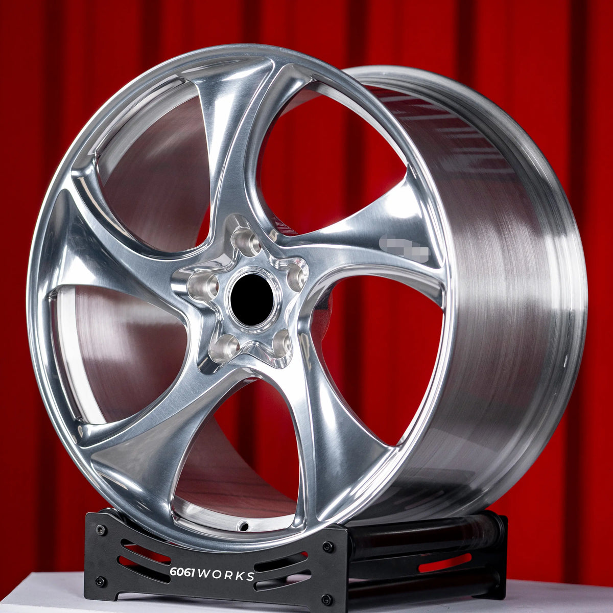 Porsche Taycan 21 inch custom forged wheels | 522M style Polished finish, angled profile view on red backdrop accentuating high-gloss mirror-polished aluminum surface