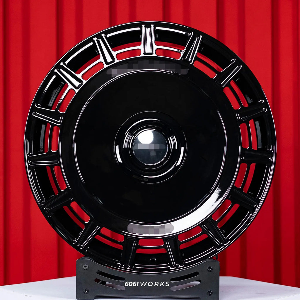 Rolls Royce Phantom 24 inch custom forged wheels | Mansory FD.15 style Gloss Black, straight front view on red backdrop stand