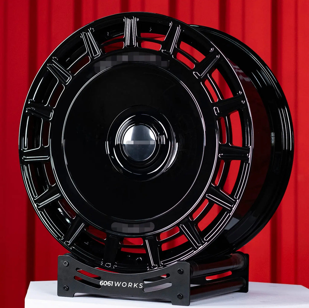 Rolls Royce Phantom 24 inch custom forged wheels | Mansory FD.15 style Gloss Black, front angled view on red backdrop stand